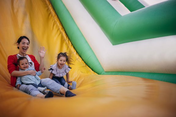 Famille Souriant et Glissant dans un Toboggan Gonflable